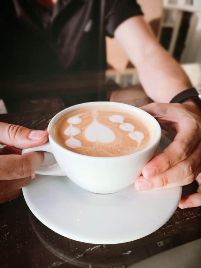 Coffee with art latte served by employee